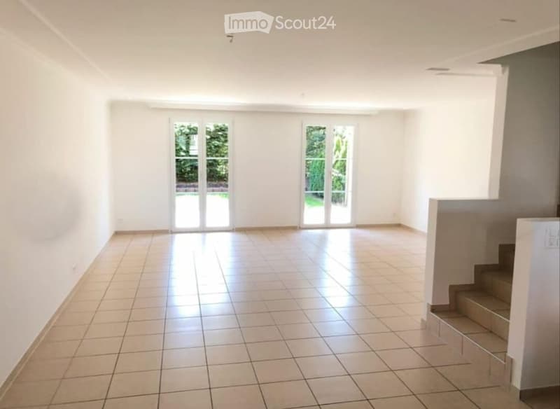Empty room with white walls, tiled floor, and large glass doors leading to an outdoor area. No furniture or equipment present.