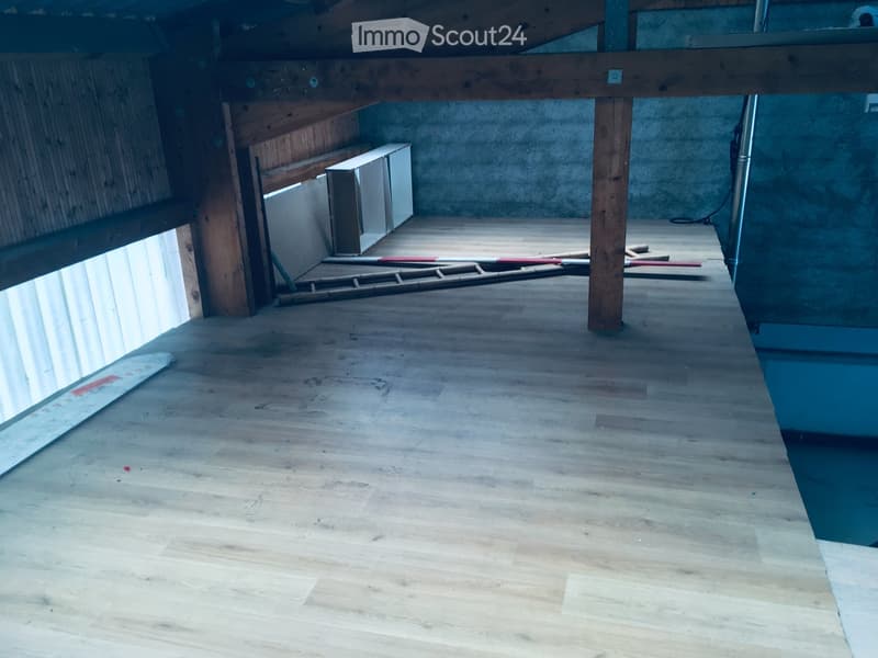 Empty room with wooden flooring, exposed wooden beams, and a small window allowing natural light. No furniture or equipment is present.