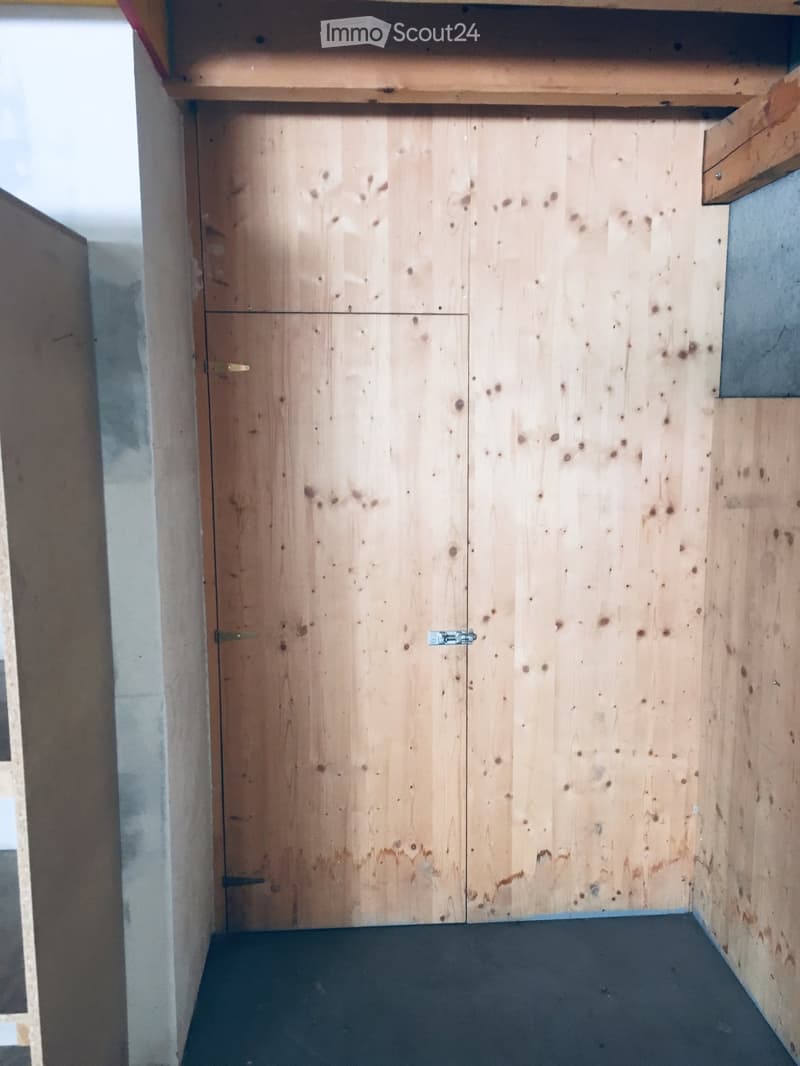 Empty room with wooden closet doors and a dark floor, no furniture or items present.