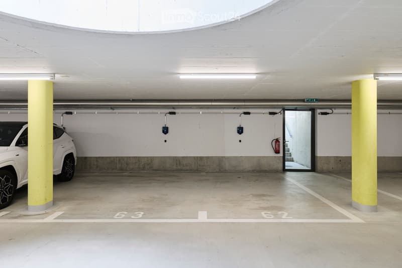 {"type": "Garage", "objects": ["car"], "description": "Underground parking area with marked parking spaces, a white car, yellow pillars, and a fire extinguisher on the wall.", "localized_descriptions": {"EN": "Underground parking area with marked parking