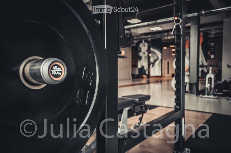 A modern gym setting with a weight machine and a bench, featuring sleek, contemporary design elements.