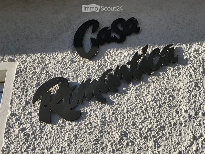 Exterior wall with the name "Casa Romantica" displayed in large, black letters.