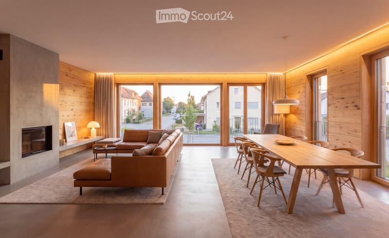 Modern living and dining area with wooden walls, large windows, a leather sofa, ottoman, coffee table, dining table with chairs, and a lamp.