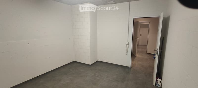 Empty room with white brick walls and a tiled floor, featuring an open doorway leading to another room.