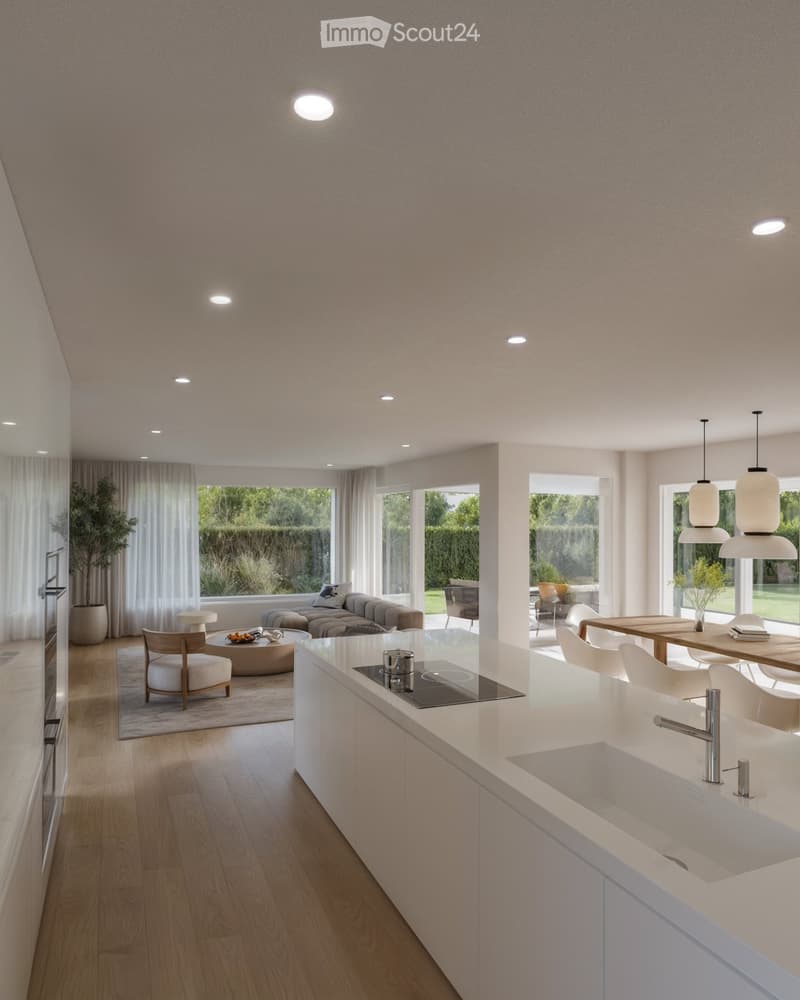 Modern open-plan living and dining area with a sleek white kitchen island, pendant lights, a sofa, coffee table, dining table, and chairs.