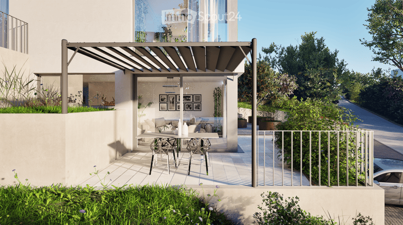 Modern outdoor patio with a pergola, dining table, chairs, and lush greenery surrounding the area.