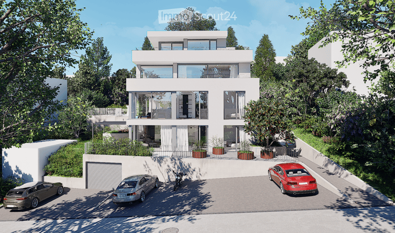Modern two-story house with white exterior, large windows, and a balcony on the upper level. The house features a garage and a parking area with several cars.