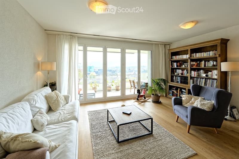 white couch, coffee table, armchair, bookshelf, rug, lamps, sliding glass doors, balcony, plants, city view