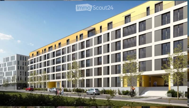 Modern multi-story building with yellow and white facade, large windows, and a raised ground floor entrance.