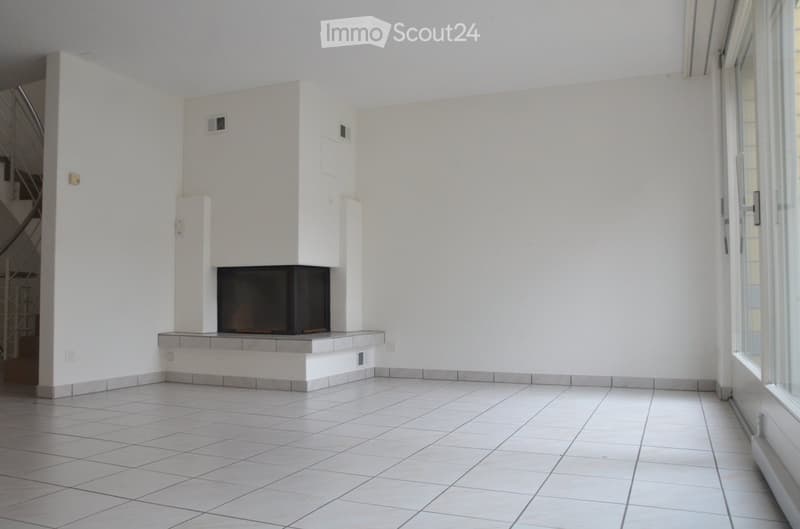 Empty room with tiled floor, white walls, and a built-in fireplace. No furniture or equipment present.