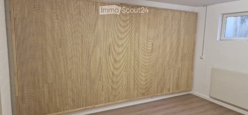 Empty room with wooden flooring, white walls, and a small window. No furniture or equipment present.