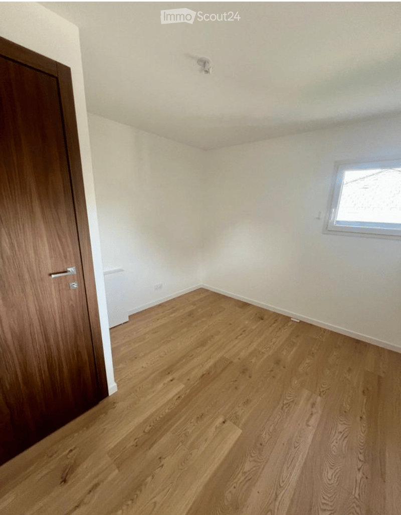 Empty room with wooden flooring, white walls, and a single window. No furniture or equipment present.