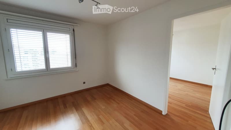Empty room with wooden flooring, white walls, and a window with blinds. No furniture or equipment is present.