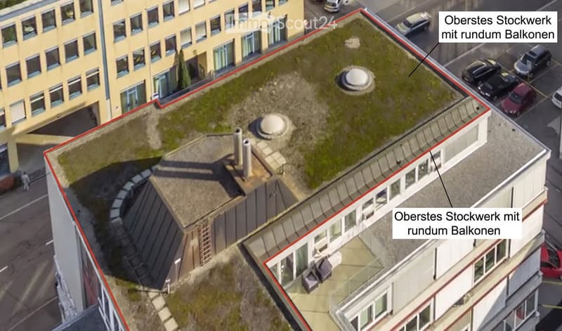 Aerial view of a multi-story building with a rooftop area featuring a small garden and round balconies.