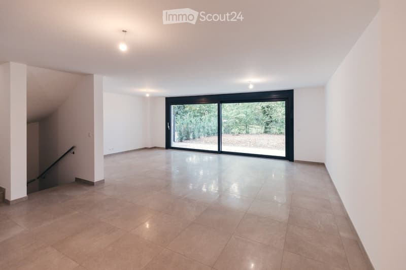 Empty room with tiled floor, white walls, large sliding glass door leading to outdoor area, staircase visible on left side.