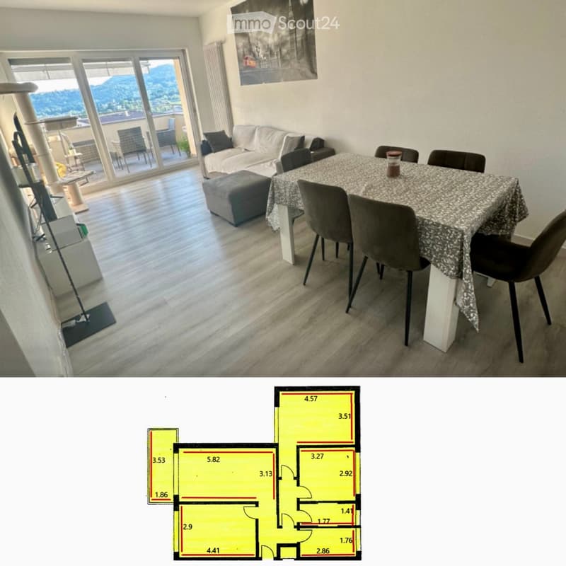 Bright living and dining area with large windows offering a scenic view, featuring a sofa, ottoman, dining table with chairs, and a cat tree.