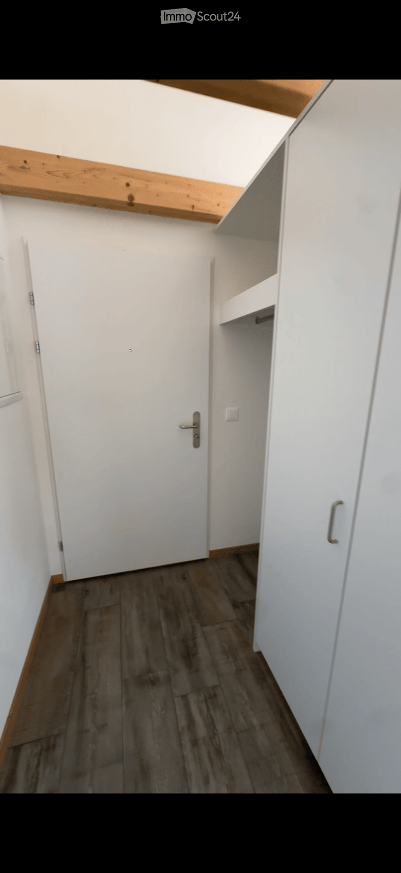 Empty room with white walls, wooden flooring, and built-in white cabinets. No furniture or personal items are present.
