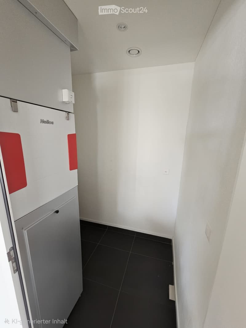 Empty hallway with white walls, black tiled floor, and a white refrigerator on the left side.
