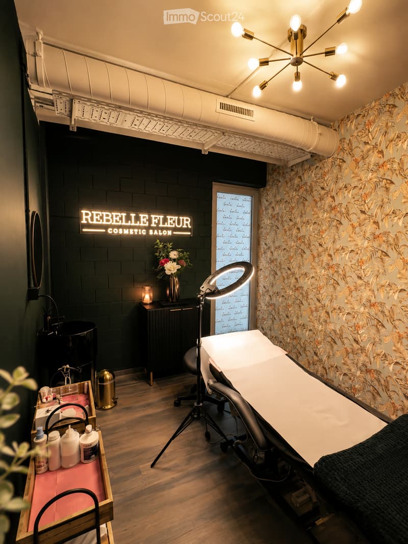 Cosmetic salon with dark brick walls, floral wallpaper, wooden floor, vanity table, chair, mirror, and decorative vase.