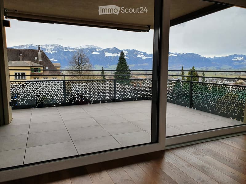 large sliding glass doors, balcony with metal railing, tiled floor, wooden floor, mountain view
