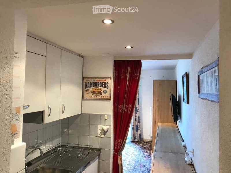 Renovated walls, tiled floor and functional kitchen with sink, fridge,