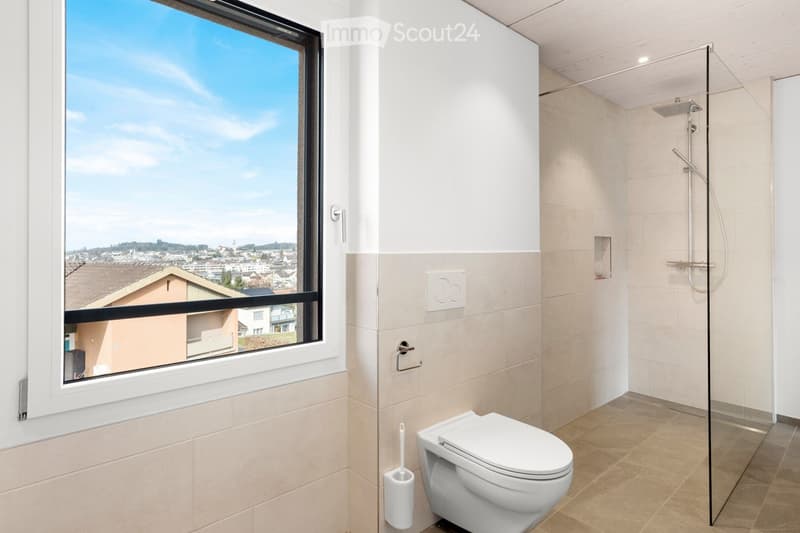 Modern bathroom with a large window offering a view of the city, a toilet, a glass-enclosed shower, and a toilet paper holder.