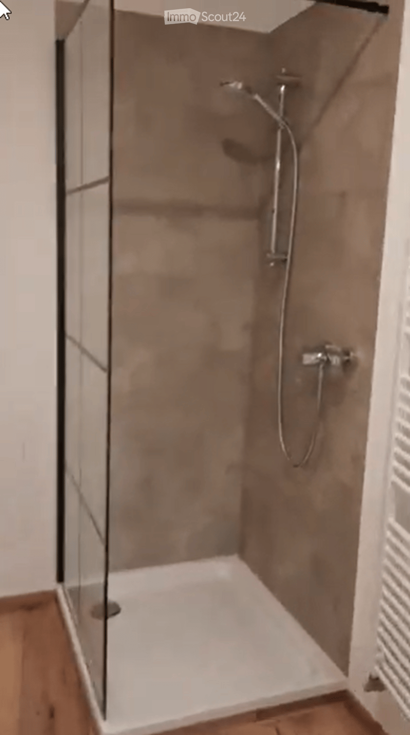 Modern shower stall with glass enclosure, sleek showerhead, and modern faucet.