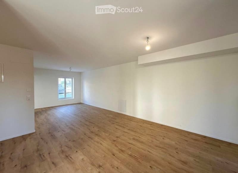 Empty room with wooden flooring, white walls, and a single window. No furniture or equipment present.