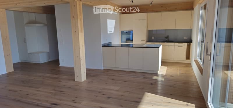 Kitchen. Modern kitchen with light-colored cabinets, a central island, and wooden flooring. Features include a sink, oven, and ample natural light from large windows.