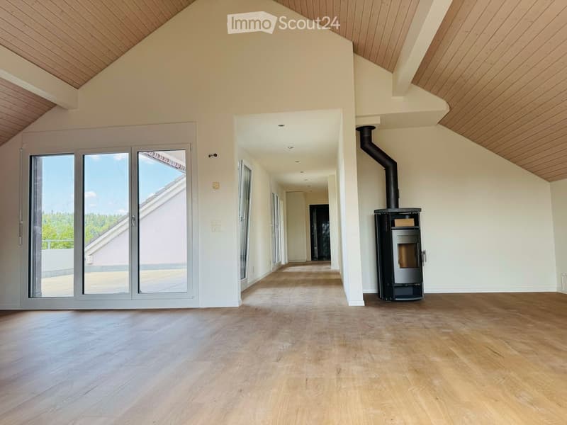 Empty room with wooden flooring, white walls, and a modern fireplace. Large sliding glass doors lead to a balcony area.