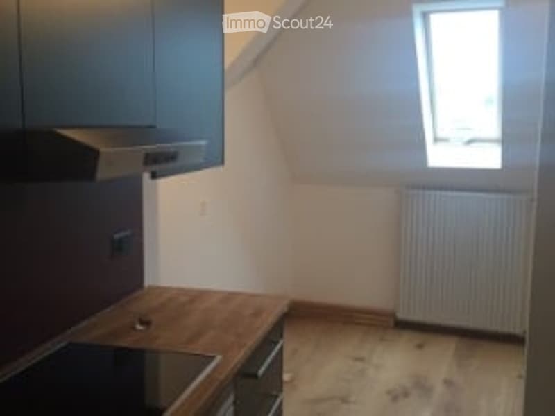 Small, empty room with wooden floor, white walls, and a single window. No furniture or equipment present.