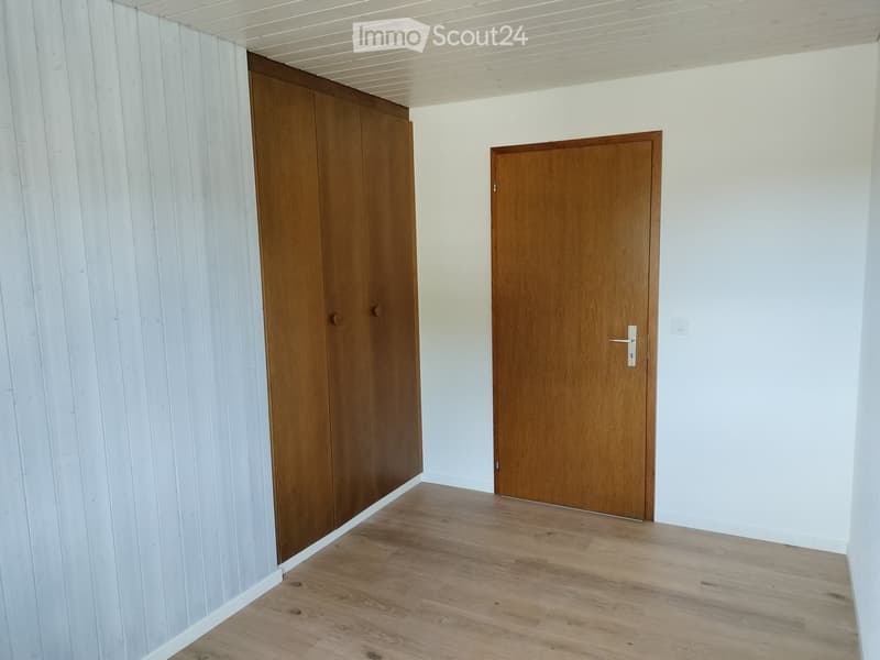 Unfurnished Room. Empty room with light wooden flooring, white walls, and two wooden doors.