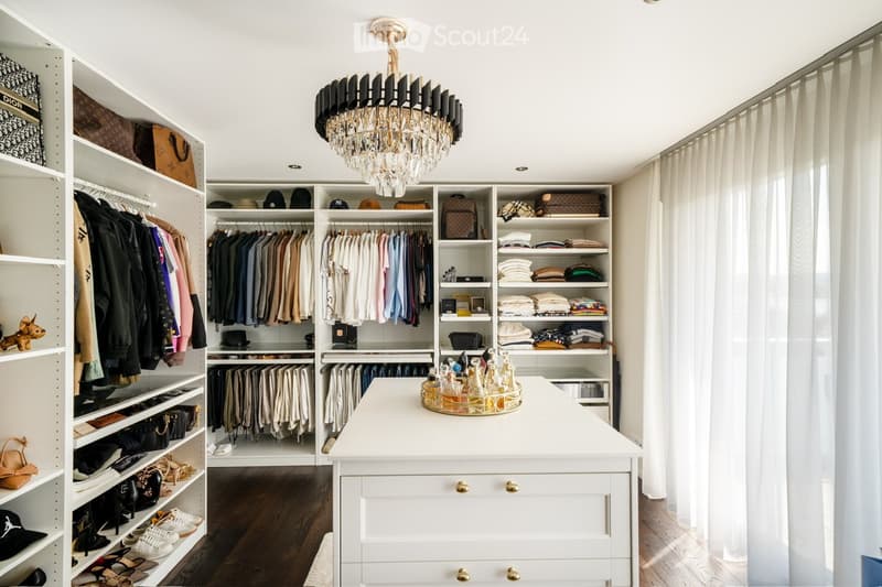 walk-in closet, hanging clothes, floor-to-ceiling shelves, chandelier, countertop, drawers, racks