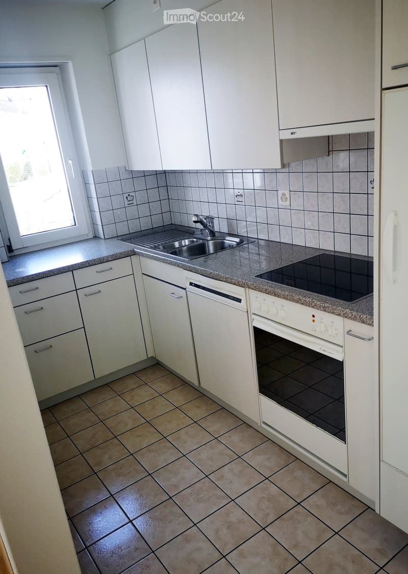 Modern kitchen with white cabinets, granite countertop, stainless steel sink, electric stove, and dishwasher.