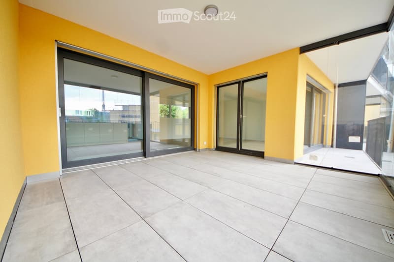 Empty balcony with large sliding glass doors, beige tiled floor, and yellow walls.