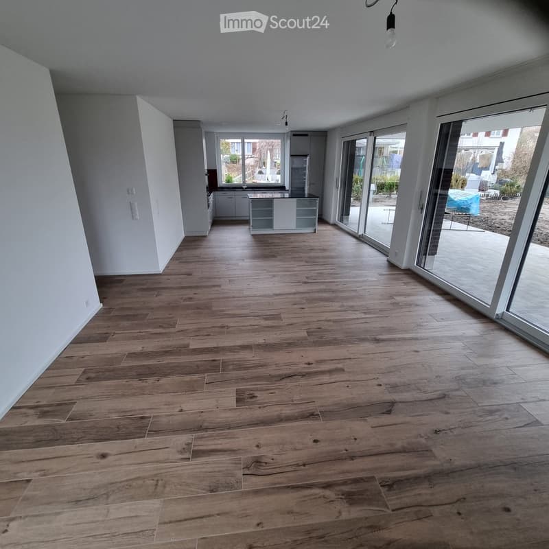 Empty room with wooden flooring, white walls, and large glass sliding doors leading to an outdoor area. No furniture or equipment is present.