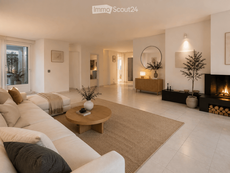 Modern living room with a white sofa, wooden coffee table, fireplace, side table, and decorative items.