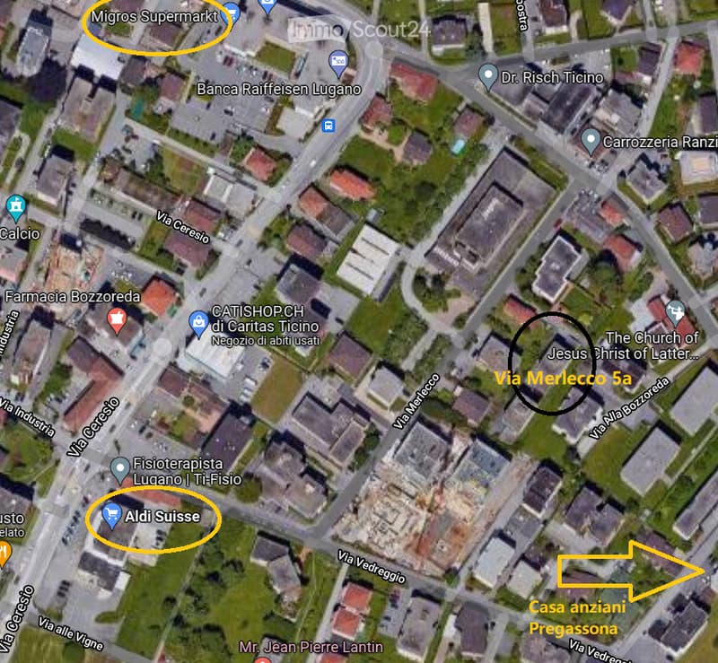 Aerial view of a residential area with streets, buildings, and labeled landmarks including Migros Supermarkt, Banca Raiffeisen Lugano, and Via Merlecco 5a.