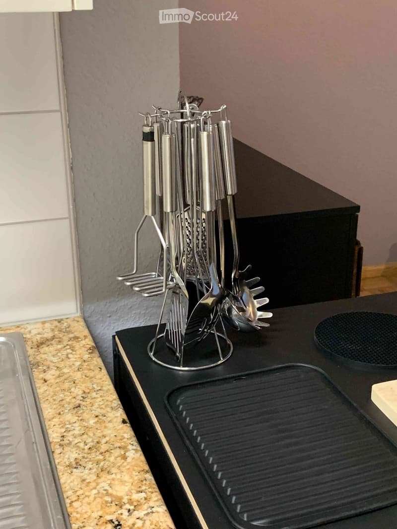 A kitchen countertop with a griddle and a utensil holder containing various kitchen tools.
