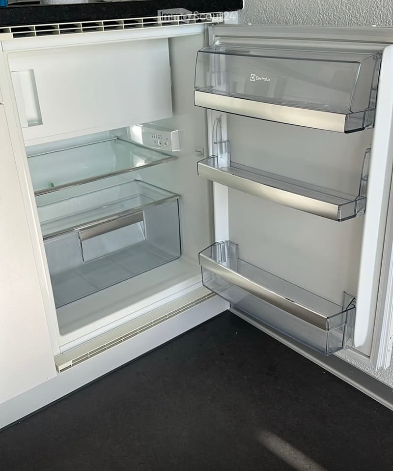 Open refrigerator with multiple glass shelves and drawers, featuring a sleek design and modern aesthetic.
