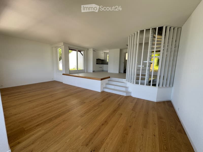 Completely empty room with wooden flooring, white walls, and a staircase leading to another level. No furniture or equipment is present.