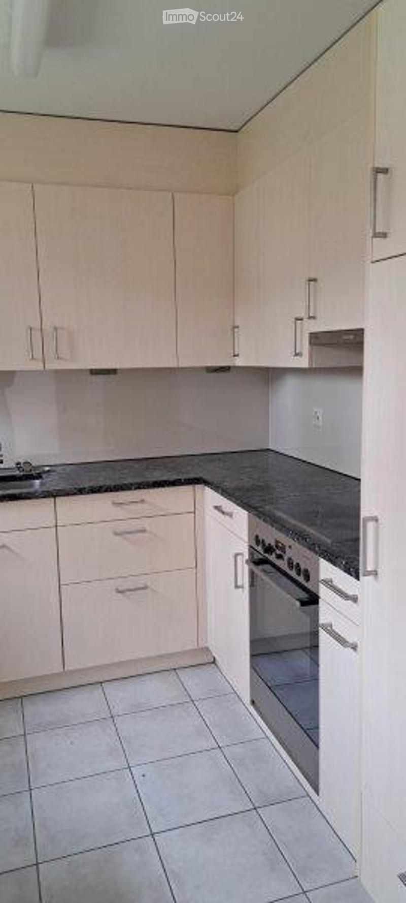 Modern kitchen with white cabinets, granite countertops, and stainless steel appliances.