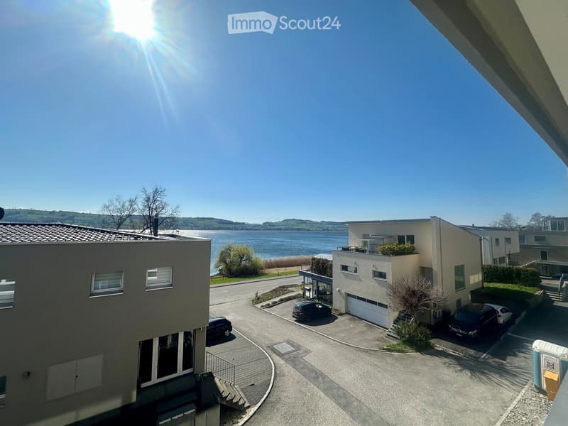Modern house with a view of the lake, 2 cars parked in front, garage, 2 floors
