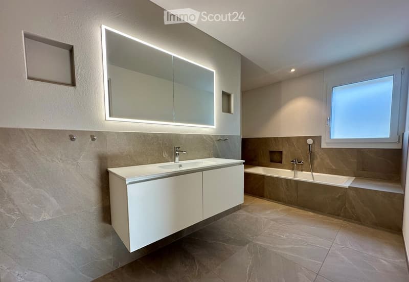 modern bathroom with white vanity, large mirror, bathtub, and tiled floor
