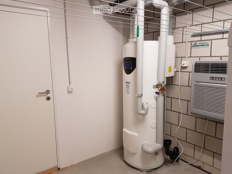 utility room with washing machine, water heater, and a water cooler