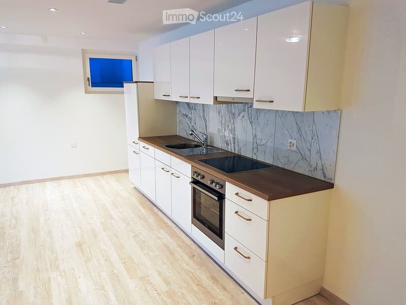 Modern kitchen, white cabinets, wooden countertops, integrated oven and stove, double sink, marble backsplash, hardwood floors