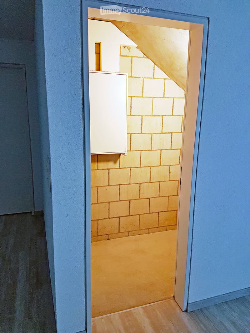 blue walls, wooden floor, yellow bricks, unfinished attic area, open door