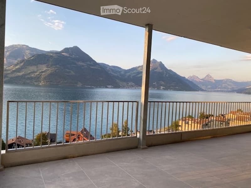 Balcony with a scenic mountain and lake view, featuring a metal railing and tiled floor.