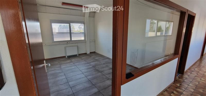 Empty room with tiled floor, white walls, and a window with blinds. No furniture or equipment present.