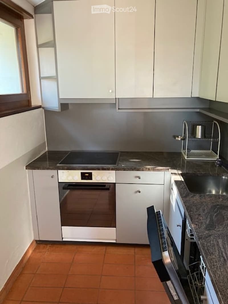Modern kitchen with white cabinets, stainless steel appliances, granite countertop, and a built-in oven and dishwasher.